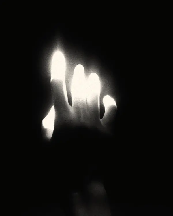 A glowing hand in complete darkness
